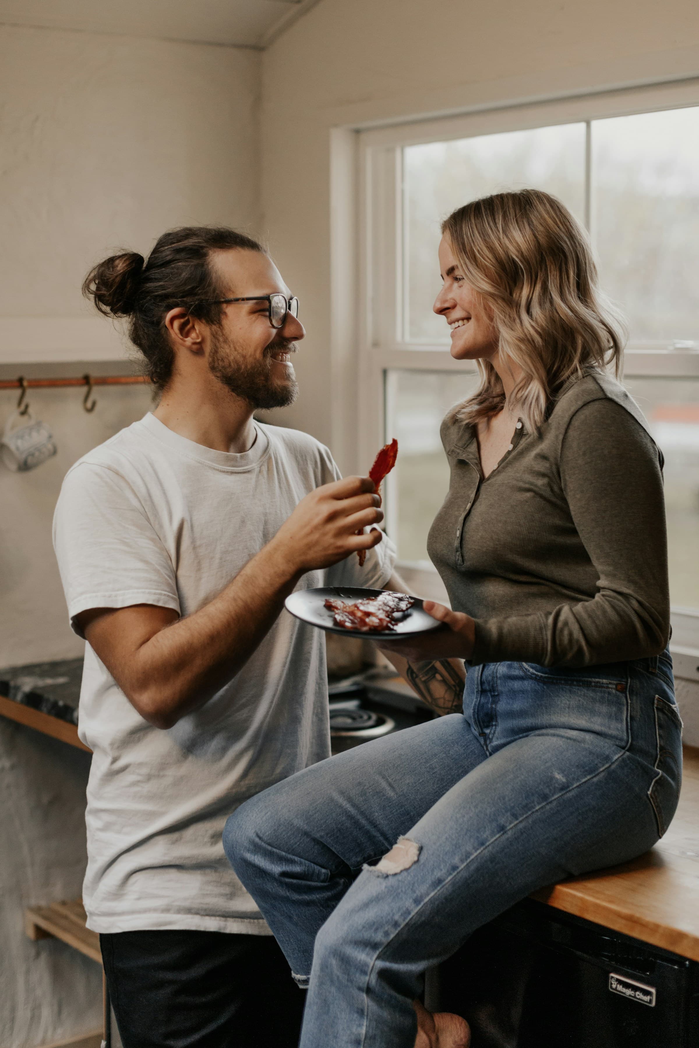 A happy couple relaxing together indoors, sharing a meal worry-free because they've split their finances fairly with plan/ria